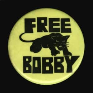 A yellow button with the words FREE BOBBY and a drawing of a black panther